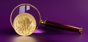 Ile karatów ma złoto? Złota moneta Filharmonik Wiedeński powiększona lupą – symbol wysokiej próby złota